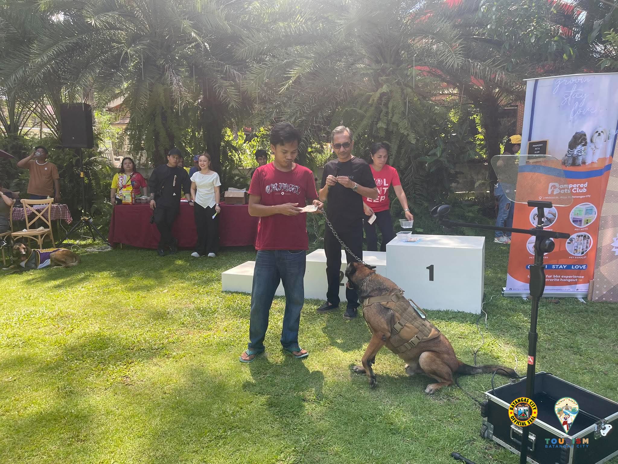 A dog sitting with its handler beside the winners' podium