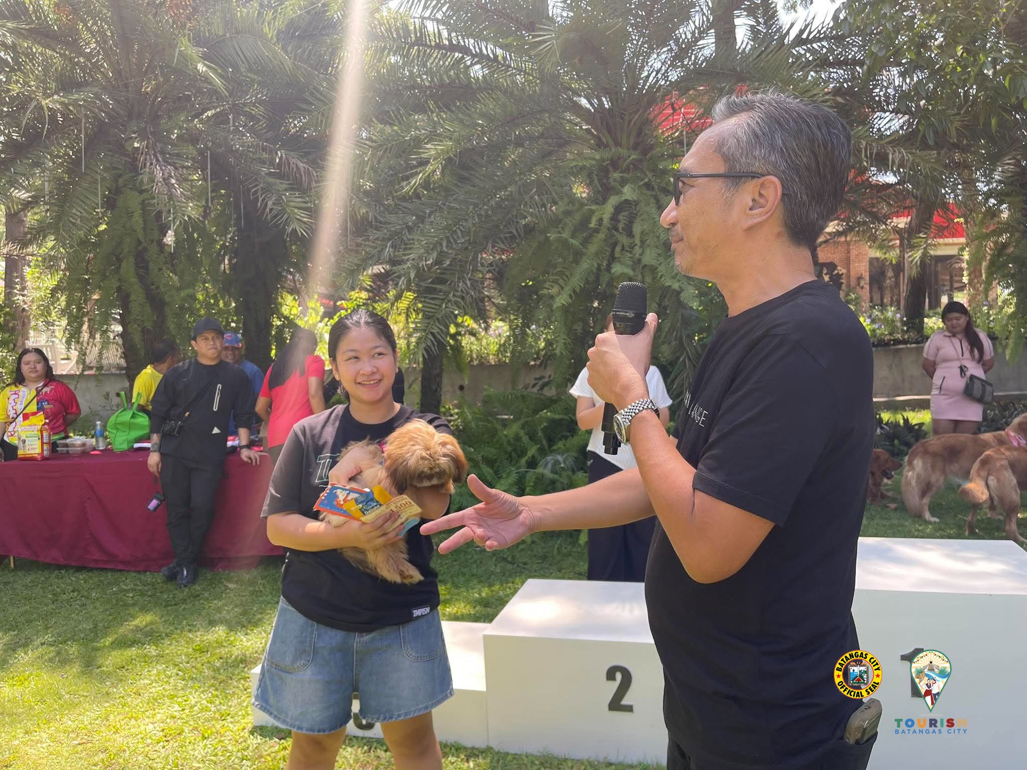 The host speaking with a participant who is holding her dog